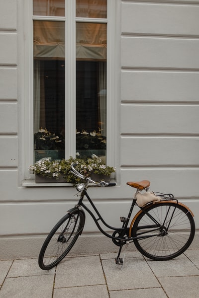 Black city bike beside the white walls
